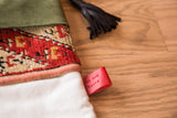 Red patterned antique rug fragment, ivory linen, and Old New House leather tag detail.