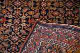 Vintage Bijar rug detail: intricate Herati motif on indigo field, madder red border, secured edge.