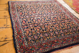 Vintage Bijar rug corner with secured red border and tightly woven dark indigo Herati pattern.