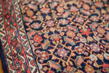 Tightly woven Herati motif on dark indigo field of vintage Bijar rug with madder root red border.