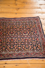 Vintage Bijar rug corner with intricate Herati motif on dark indigo field and madder red border.
