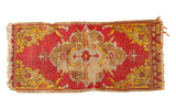 Distressed Yastik rug: brick red and saffron yellow scalloped medallion, with tattered ends.