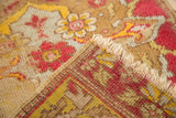 Tattered fringe and hand-knotted weave on an antique distressed Yastik rug.