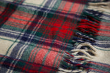 Close-up of vintage plaid blanket, highlighting fuzzy wool texture and red, green, navy fringe.