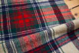 Folded section of vintage plaid wool blanket in classic red, green, blue, cream.
