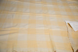 Detail of sunshine yellow plaid pattern and hand-backed cotton edge on vintage wool blanket.