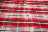 Soft wool texture of vintage plaid blanket in red, white, green, and blue.