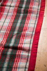 Vintage wool blanket's mid-century plaid with classic red, green, blue, and satin edge.