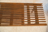 Close-up of the vintage MCM slat bench's expandable wooden slats, showing age and wear.