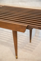 Mid century modern expandable slat bench sliding joint and tapered brass-capped leg.