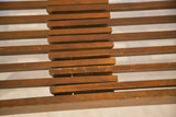 Brown wooden slats of the vintage MCM bench, with visible chips and age wear.
