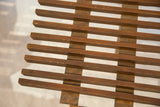 MCM slat bench's brown wooden slats, revealing vintage wear, chips, and nicks.