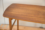 Mid-century modern teak tabletop with visible lightening and circular stain.