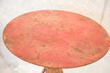 Distressed red round top with industrial patina on the vintage bistro table.