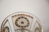 Gold crown and shield motif on clear glass ice bucket.