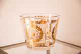 Clear glass Mid Century ice bucket with a reflective gold crown medallion design.