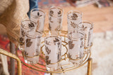 Eight Mid Century frosted glasses with silver fall leaves on a gold caddy.
