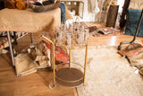 Hollywood Regency vintage brass bar cart with two round tiers, cup holders, and handle.