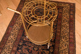 Hollywood Regency round brass bar cart with cup holders and lower wooden shelf.