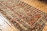 Distressed rectilinear geometric border and field motifs of the antique Caucasian rug.