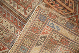 Distressed corner of antique Caucasian rug, geometric serpent design, low pile, secured edge.