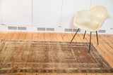 Distressed texture revealing geometric rectilinear design in muted cherry red, indigo, and ivory.