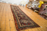Vintage Caucasian runner, madder red and teal tribal medallions, with visible width variation.