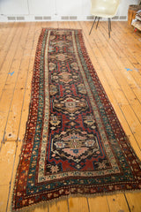 Vintage Caucasian runner's intricate tribal geometric medallions with madder red and teal.