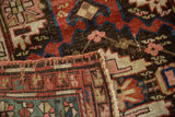 Secured side detail of hand-knotted tribal pattern in madder root red and teal.