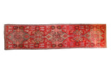 Distressed Antique Karabagh runner: brilliant blood orange field, repeating medallions, floral motifs.