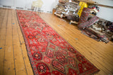 Antique Distressed Karabagh runner rug with prominent repeating medallions, botanical motifs, blood orange, green, ivory.