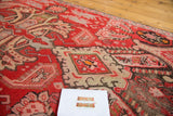 Decorative distressed texture on a Karabagh runner, showcasing rich red, ivory, and green patterns.