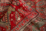 Distressed Karabagh runner detail: brilliant red field, sea foam green motifs, frayed border.