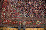 Distressed Mahal rug corner: indigo guli-hinnai pattern transitioning to black cherry border.