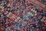 Faded indigo field and guli-hinnai henna plant motif on a distressed vintage Mahal carpet.
