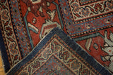 Distressed Mahal carpet corner, highlighting rich red field and dark blue border patterns.