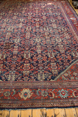 Distressed Mahal carpet corner with indigo henna plant design and professional seam.