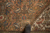 Distressed texture of antique Mahal carpet, faded peach and blue Herati design, visible split.