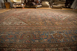 Distressed blue border with turtle motifs and faded peach Herati pattern.