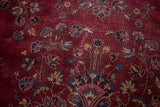 Distressed plum field of vintage Turkish rug, with faded blue and gold floral motifs.