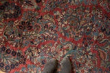 Exquisite floral bouquets in blue, green, and neutral tones on a cherry red Sarouk rug.