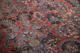 Intricate Persian Sarouk floral pattern in blue, green, and cream on a cherry red field.