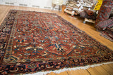 Vintage Heriz carpet's geometric field, with cherry red, deep blue, and natural patina.