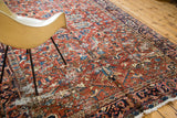 Textural detail of the vintage Heriz carpet, highlighting worn pile with cherry red and deep blue.