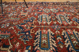 Distressed vintage Heriz carpet texture in bold cherry red, deep blue, and blush patterns.