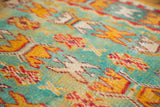 Textured pile of vintage Murat runner with mint green, yellow, and red reciprocating motifs.