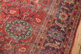 Distressed coral-red field and unique lavender-mauve border on an antique Sultanabad carpet.