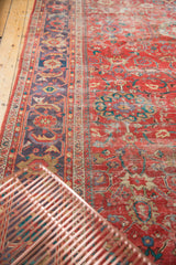 Antique Persian Sultanabad carpet detail: coral-red field, unique lavender border, worn pile texture.