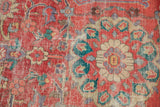 Distressed coral-red field of an antique Sultanabad, with lavender and teal floral motifs.
