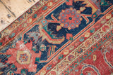 Detail of antique Sultanabad with coral-red field, navy floral elements, lavender-mauve accents, knot-head wear.